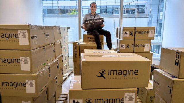 Yannick Olivier, de France Télévisions, est assis sur un lot d'appareils Imagine SNP–XS qui vient d'être livré, illustrant ainsi le déploiement à grande échelle de ce matériel par le diffuseur.
